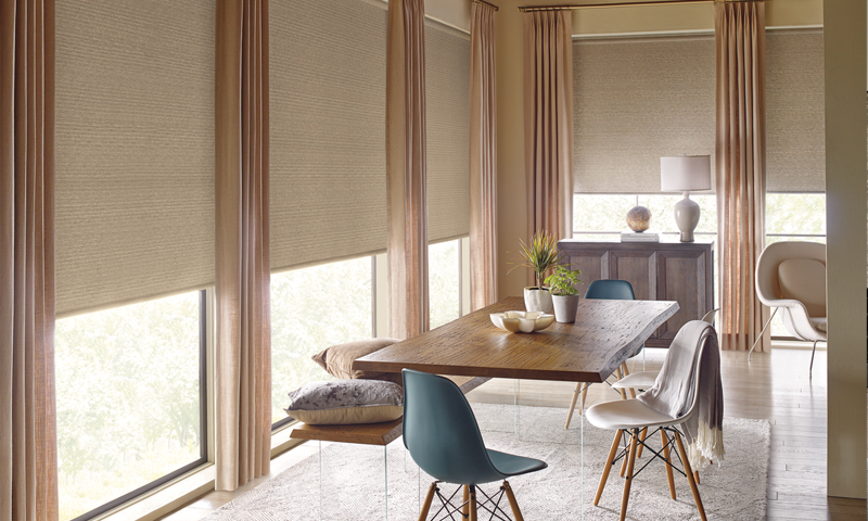 Contemporary living room with Lutron cellular shades, bright red accents, and a fireplace.