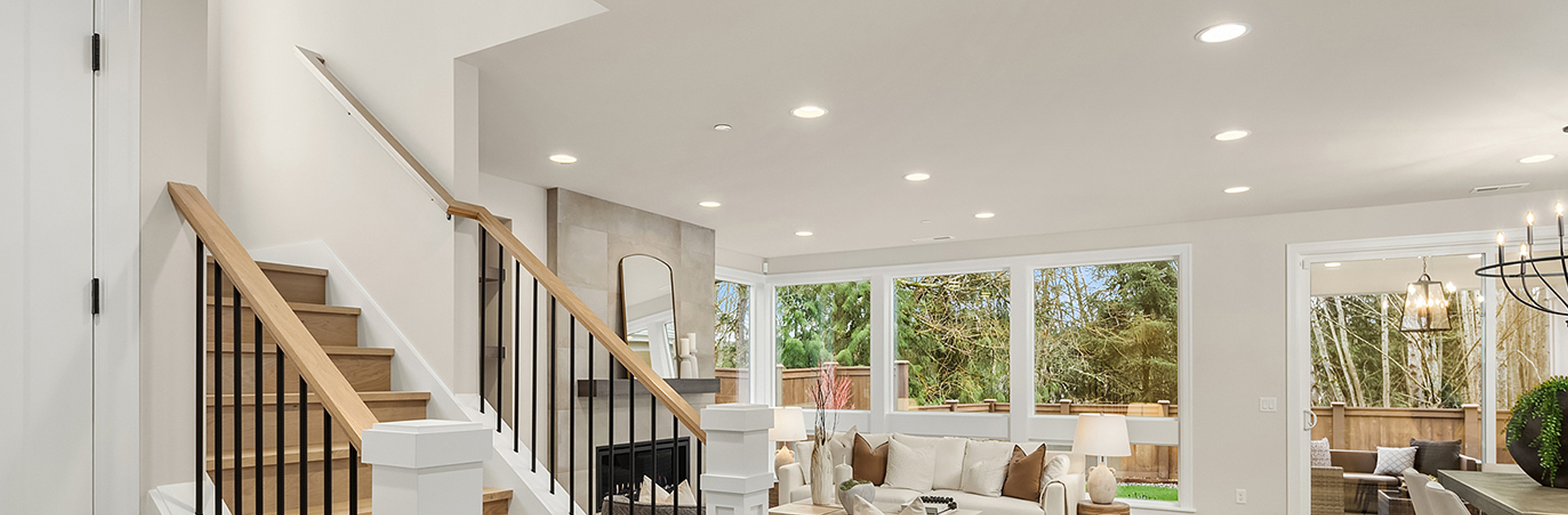 Modern home exterior illuminated with downlights showcasing architectural features and large windows.