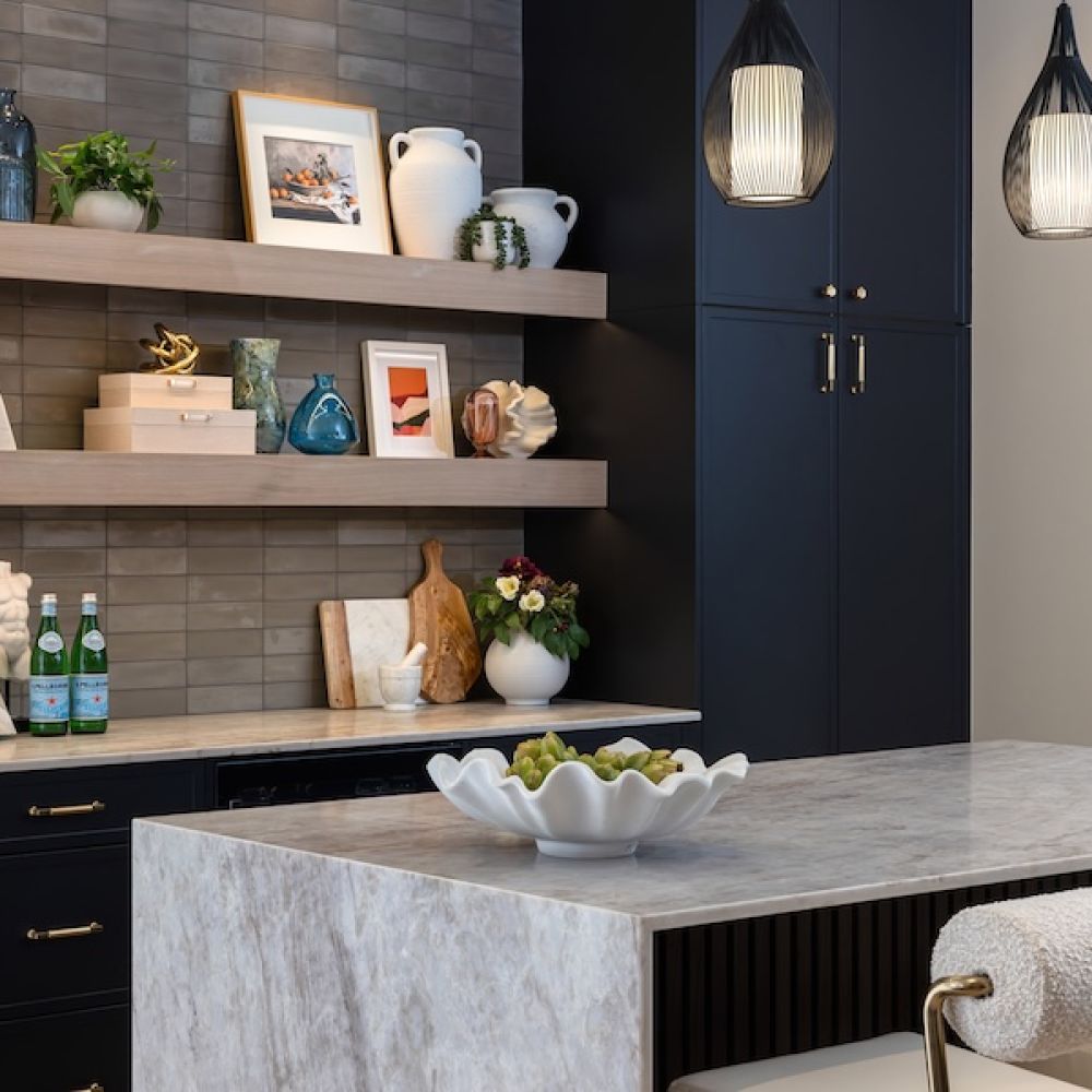 <span class="uk-h4">Luxury bar showroom with a marble island, floating wood shelves, black cabinets, and warm architectural pendant lighting.</span>